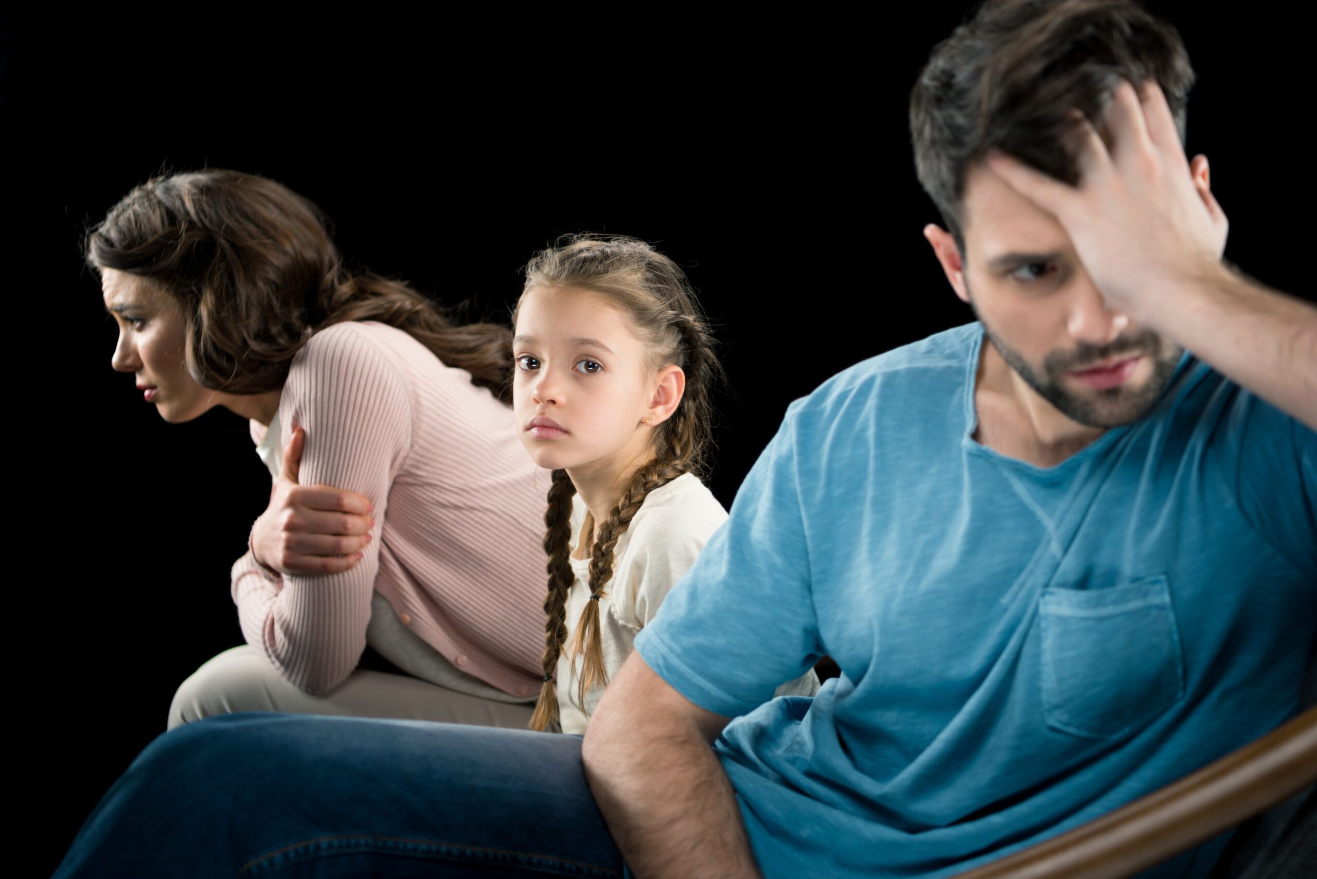Unhappy child sitting between parents who are turned away from each other | Philadelphia child custody lawyers at Vetrano | Vetrano & Feinman